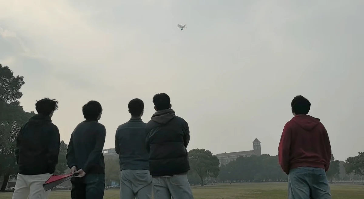 A pilot and onlookers watching EAGLE X in flight